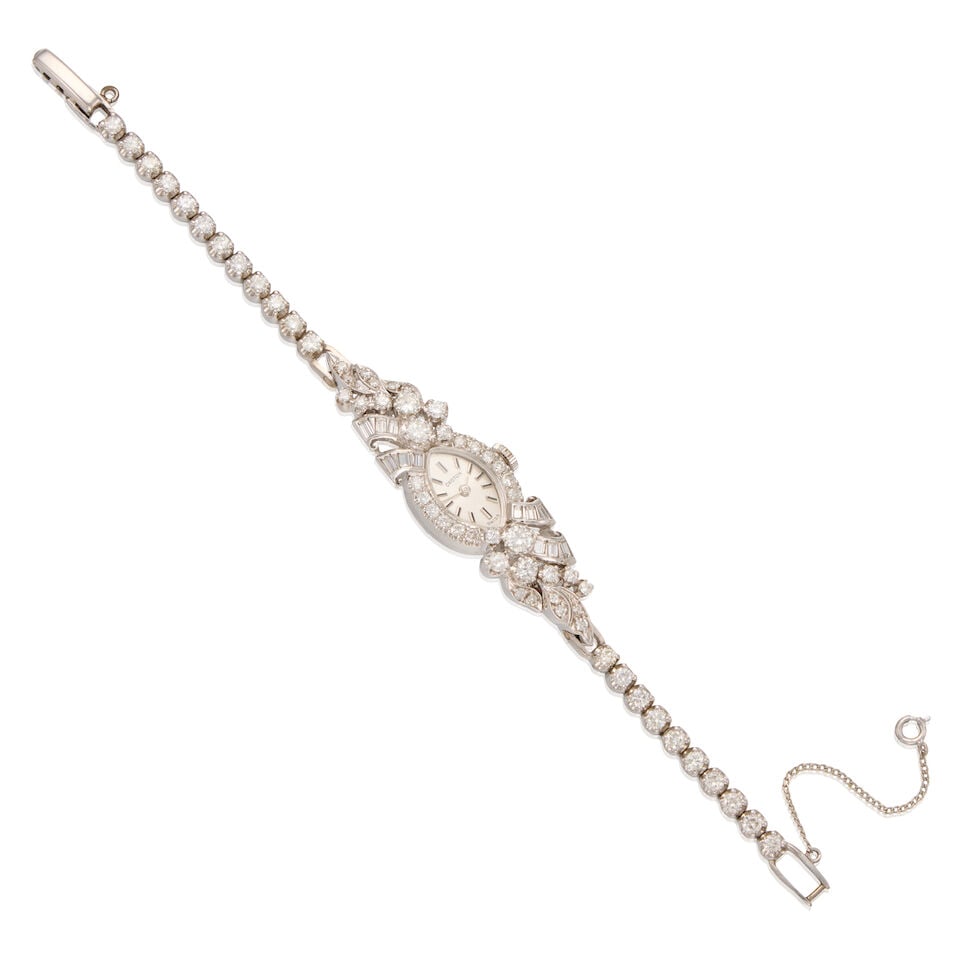A 14K WHITE GOLD AND DIAMOND WRISTWATCH: A 14K WHITE GOLD AND DIAMOND WRISTWATCH • 14K gold watch case with safety chain • Numerous single cut and round brilliant cut diamonds weighing approximately 4.30 carats total and twelve b