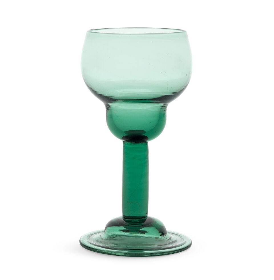 A green tinted plain stem goblet or large wine glass, circa 1750: A green tinted plain stem goblet or large wine glass, circa 1750 In light green glass, the generous cup-shaped double ogee bowl raised on a plain stem, over a folded domed foot, 15.2cm