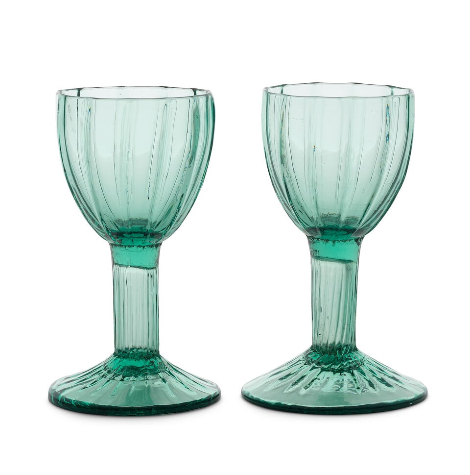 A pair of green tinted hollow stem wine glasses, late 18th century: A pair of green tinted hollow stem wine glasses, late 18th century In pale green glass, the generous rib-moulded ovoid bowls set on hollow stems moulded with fine flutes, the conical feet spirally
