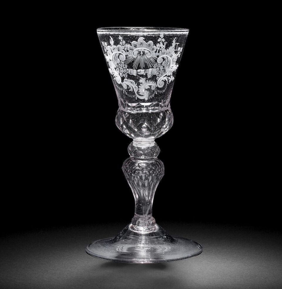 A Dutch engraved baluster 'Friendship' goblet, circa 1740: A Dutch engraved baluster 'Friendship' goblet, circa 1740 The glass German, with a generous thistle bowl, the solid beaded base cut with diamond facets, decorated with a pair of clasped hands emerging