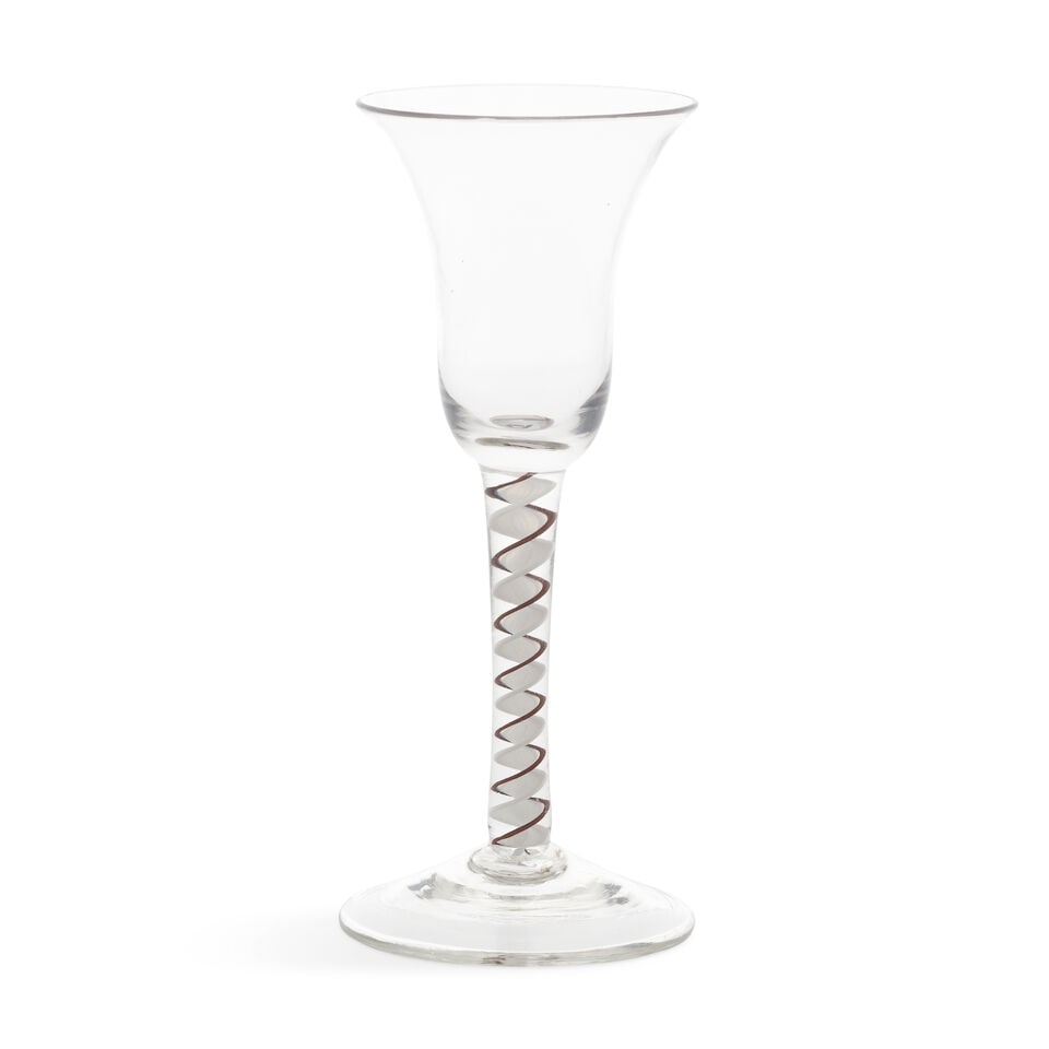 A fine brown colour twist wine glass, circa 1765: A fine brown colour twist wine glass, circa 1765 The slightly waisted bell bowl on a stem containing a solid opaque white multi-ply corkscrew, edged in opaque brown on one side and in opaque white on 