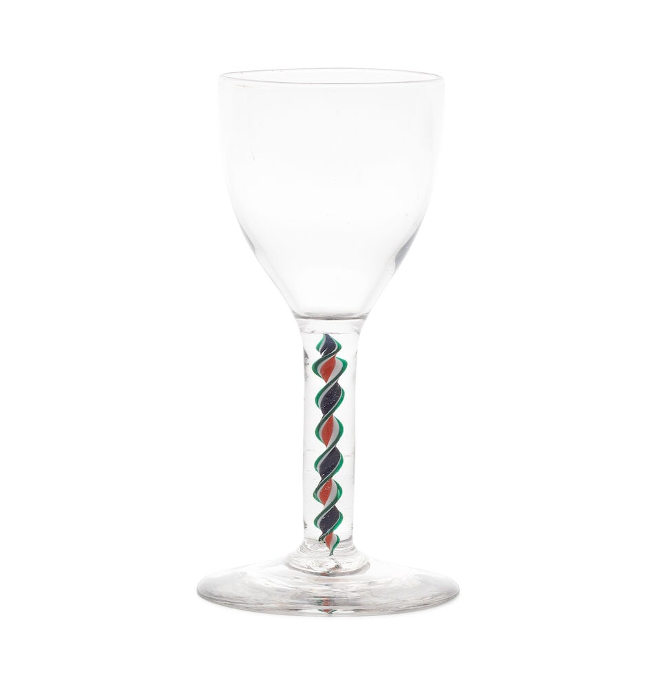 An unusual colour twist wine glass, probably late 18th century: An unusual colour twist wine glass, probably late 18th century The tulip-shaped ovoid bowl on a stem enclosing a red, blue and opaque white corkscrew edged on both sides in translucent emerald-green,
