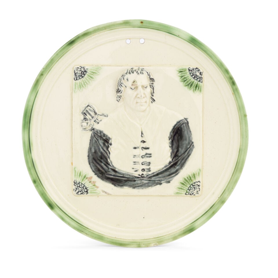 A remarkable Staffordshire lead-glazed creamware portrait plaque of Sir Isaac Newton, circa 1775: A remarkable Staffordshire lead-glazed creamware portrait plaque of Sir Isaac Newton, circa 1775 Of circular shape, the turned rim washed in green, the centre reserved with a square tile moulded in hi
