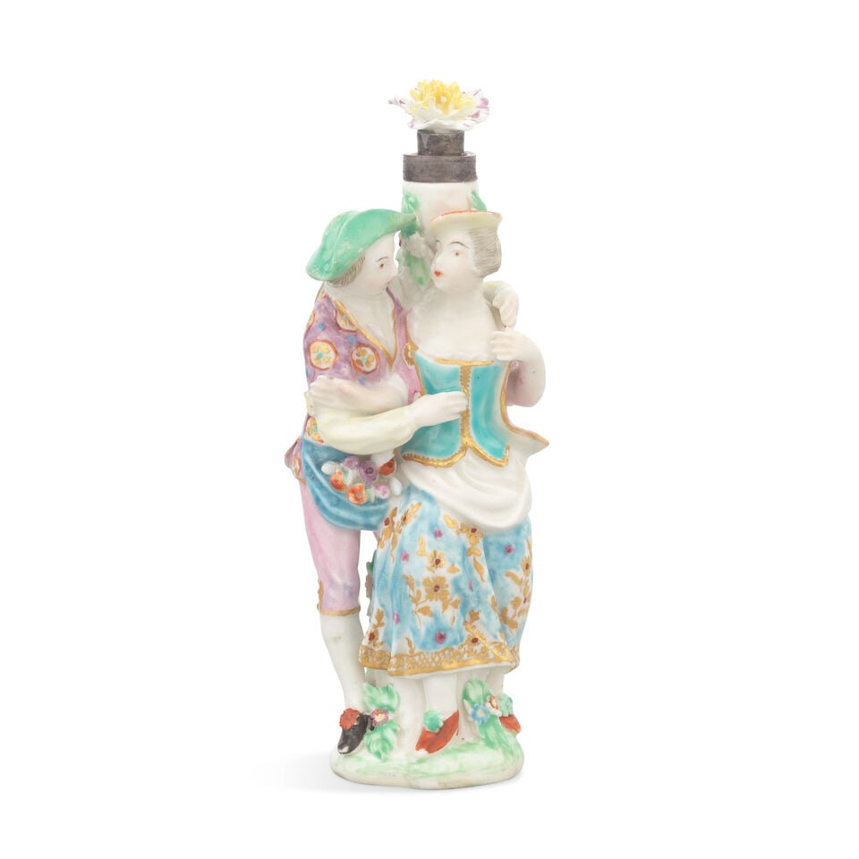 A Chelsea scent bottle and stopper, circa 1765: A Chelsea scent bottle and stopper, circa 1765 Modelled as a young man embracing a lady, both figures wearing brightly coloured and gilded costumes, he with a patterned jacket and she with a floral pa