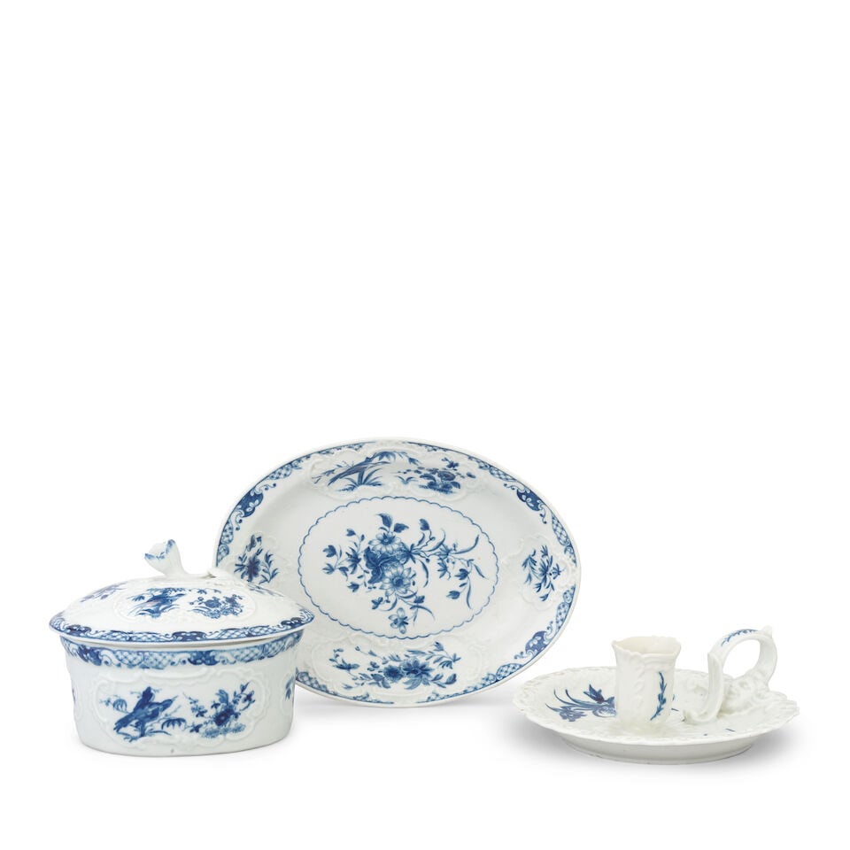 A Worcester potting pot, cover and stand and a chamberstick, circa 1765-70: A Worcester potting pot, cover and stand and a chamberstick, circa 1765-70 The oval potting pot or tureen with finely moulded cartouches, painted with the 'Bamboo Bird' pattern, stand 20cm wide, stand