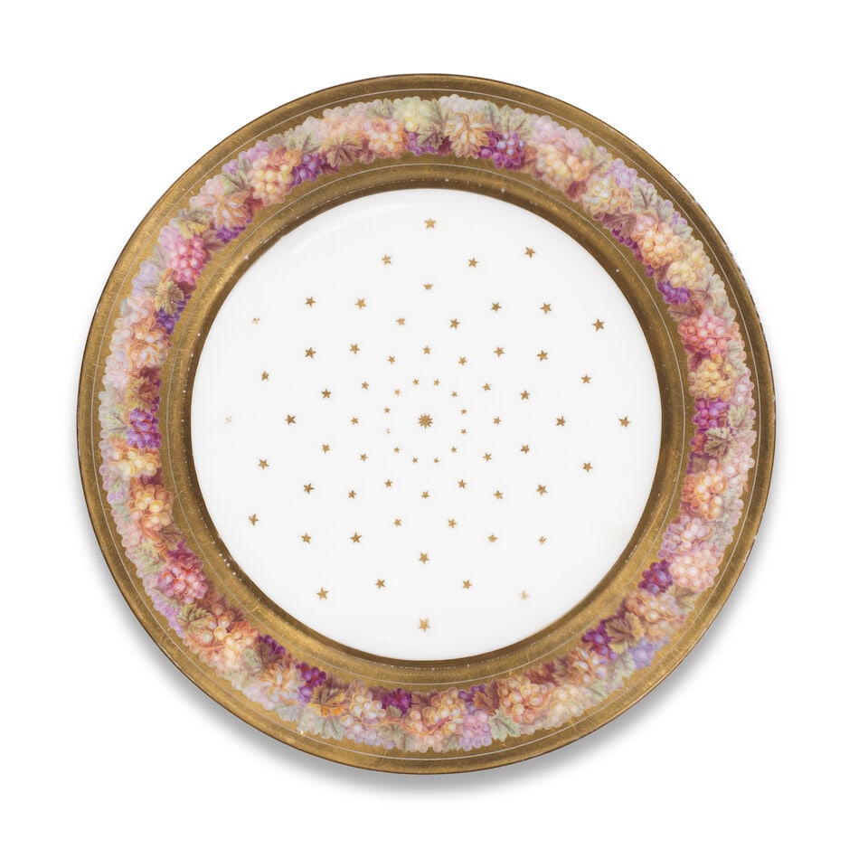 A rare Sèvres plate, circa 1804-05: A rare Sèvres plate, circa 1804-05 The rim with a gilt border painted with a dense garland of grapes and vine leaves, the well scattered with radiating gilt stars, 23.5cm diam., M.Imp.le/de Sevre