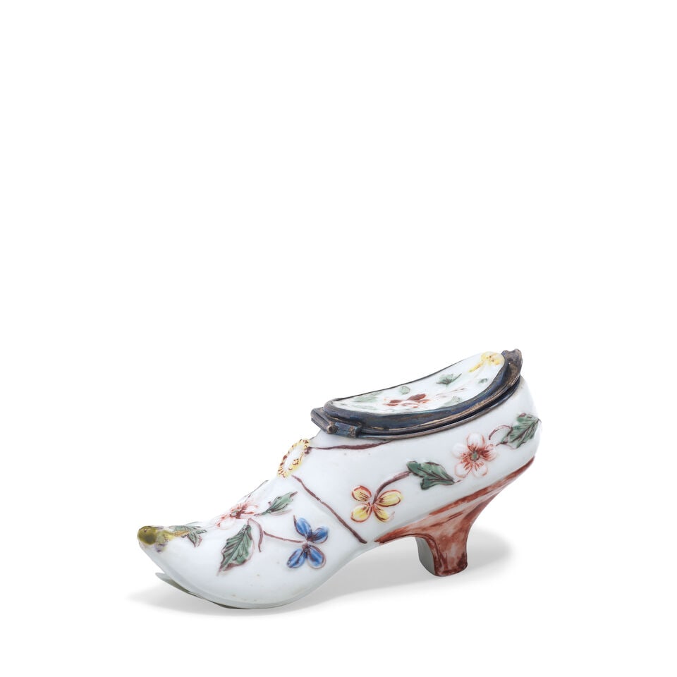 A Mennecy silver-mounted snuff box modelled as a shoe, circa 1755: A Mennecy silver-mounted snuff box modelled as a shoe, circa 1755 Moulded with trailing foliage and flowers picked out in polychrome enamels, the heel painted in brown, the mount with a Paris