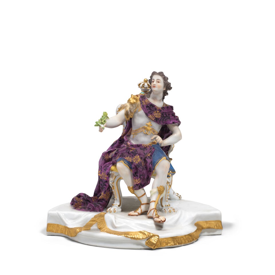 A Meissen figure emblematic of France, second half 19th century: A Meissen figure emblematic of France, second half 19th century After the model by J.J. Kaendler of 1746, as a Roman emperor, the figure seated on a richly-scrolled chair surmounted by a crown,