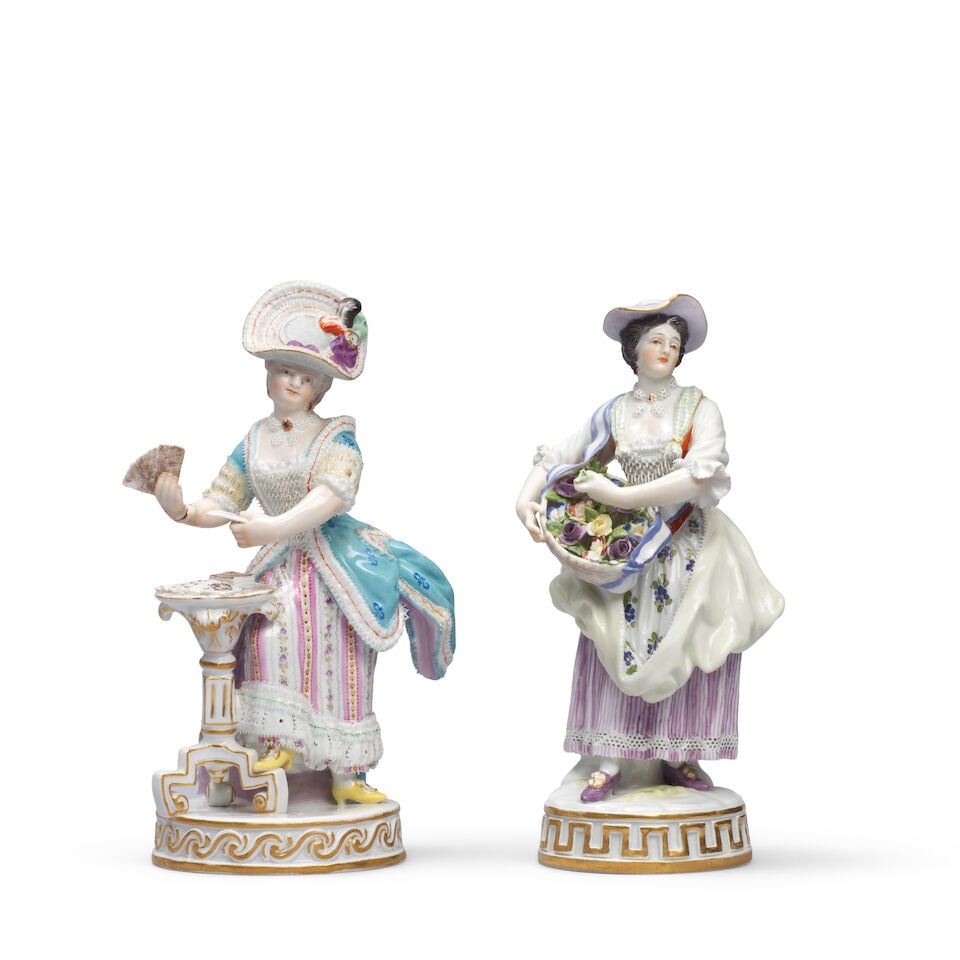 Two Meissen figures of ladies, late 19th century: Two Meissen figures of ladies, late 19th century After the late 18th-century models by M.V. Acier, the first wearing a lace-edged hat and dress playing cards in a small table; the second holding a bas
