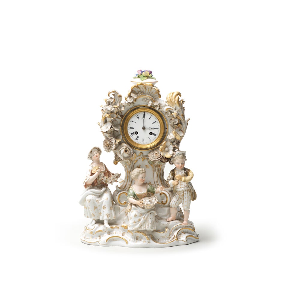 A Meissen clock case, late 19th century: A Meissen clock case, late 19th century Probably decorated outside the factory, moulded with scrollwork and pierced trellis panels at the sides, the clock enclosed by foliate scrolls and applied
