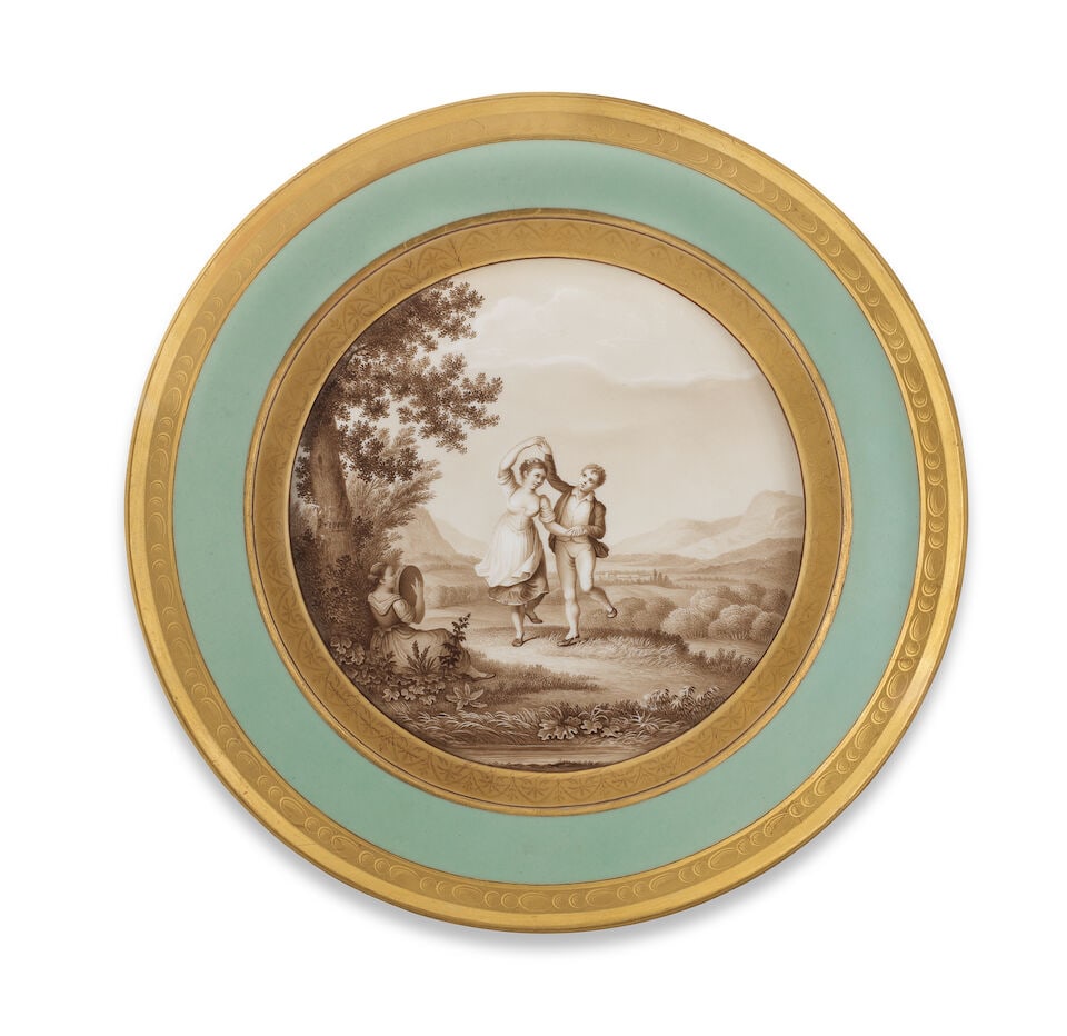 A Berlin plate, circa 1817-23: A Berlin plate, circa 1817-23 With a sunken well decorated with a pair of Italian dancers in grisaille with a girl playing a tambourine in a landscape, the pale green border with gilt pebble rim,