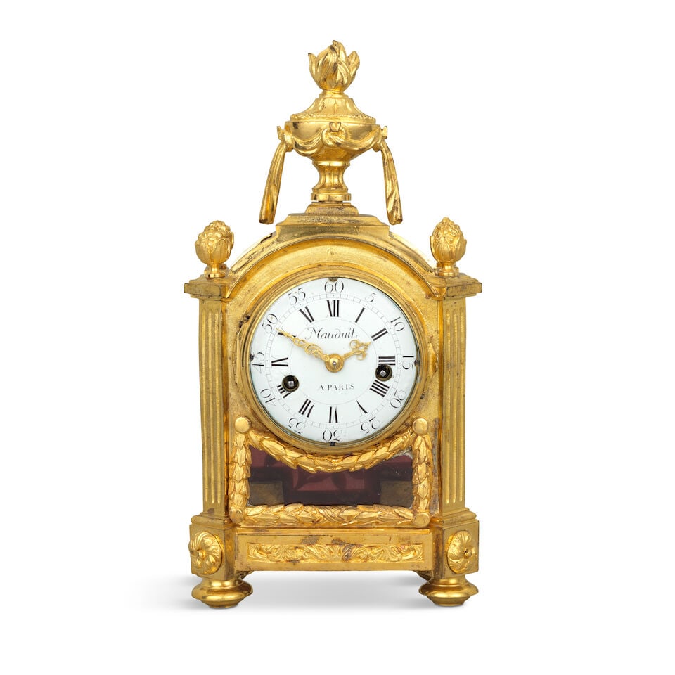 A fine late 18th century French ormolu mantel clock Mauduit a Paris: A fine late 18th century French ormolu mantel clock Mauduit a Paris The break arch case surmounted by a flaming urn finial over four foliate finials and canted fluted pilasters, the front with glazed 