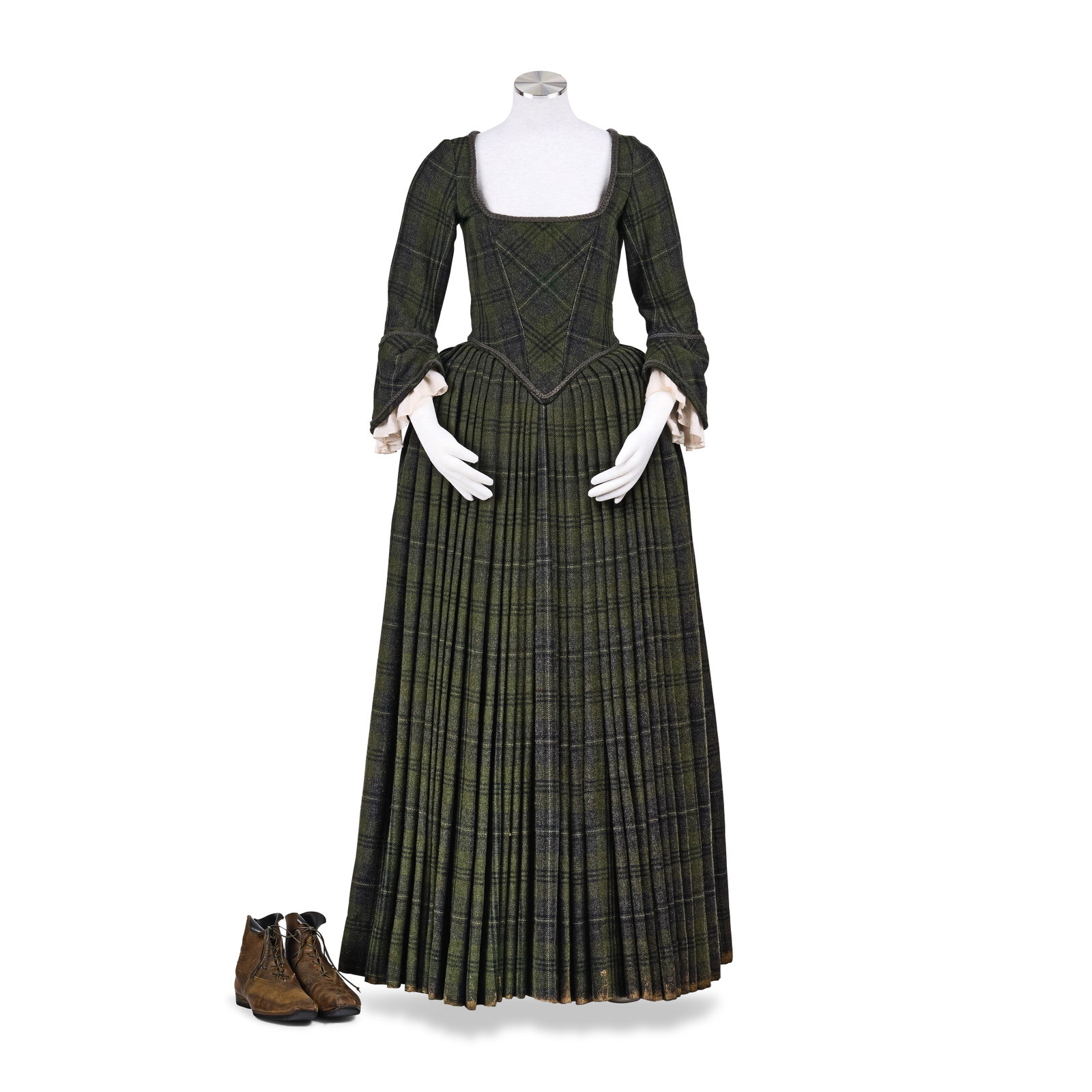 Claire's tartan corseted dress Season 1, Episode 12, 'Lallybroch' 2: Claire's tartan corseted dress Season 1, Episode 12, 'Lallybroch' Comprising: a custom-made tartan dress with pleated skirt, in green and grey, with white trimmed linen sleeves; with brown faux-leathe