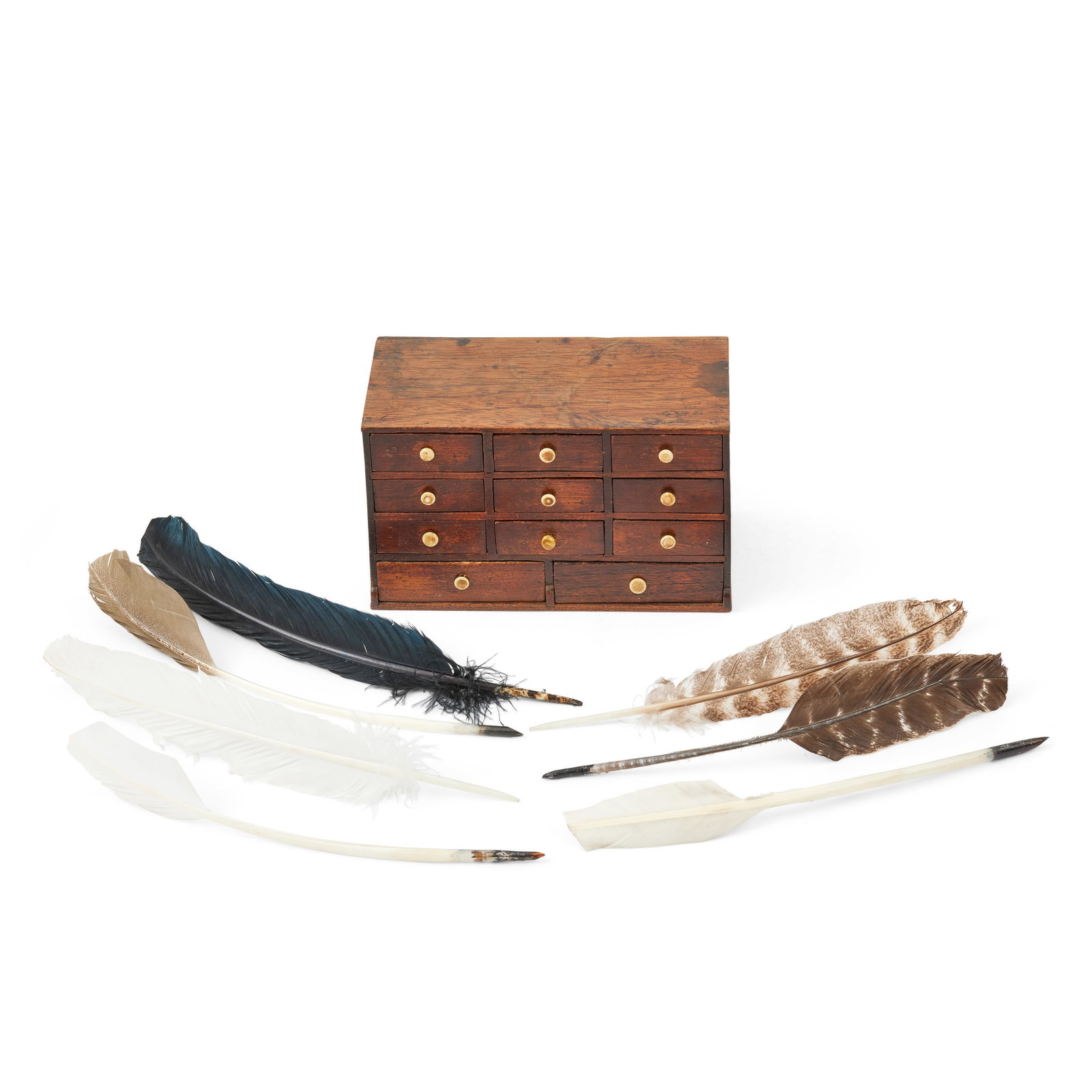 A late 19th century teak and rosewood miniature chest, used by Jamie Possibly Indian: A late 19th century teak and rosewood miniature chest, used by Jamie Possibly Indian With eleven drawers mounted with turned ivory handles, together with six feather quills of varying species, 19cm wi