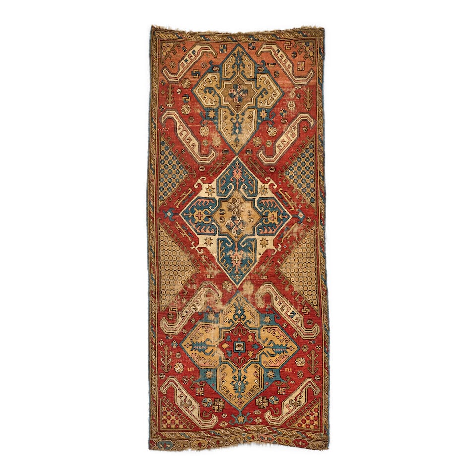 Armenian Rug Caucasus 4 ft. 1 in. x 9 ft. 5 in.: Armenian Rug Caucasus c. 1850, a playful and spacious red-field design with soft yellow and blue medallions. Linework and medallion tertiary elements harken back to classical Anatolian production and 