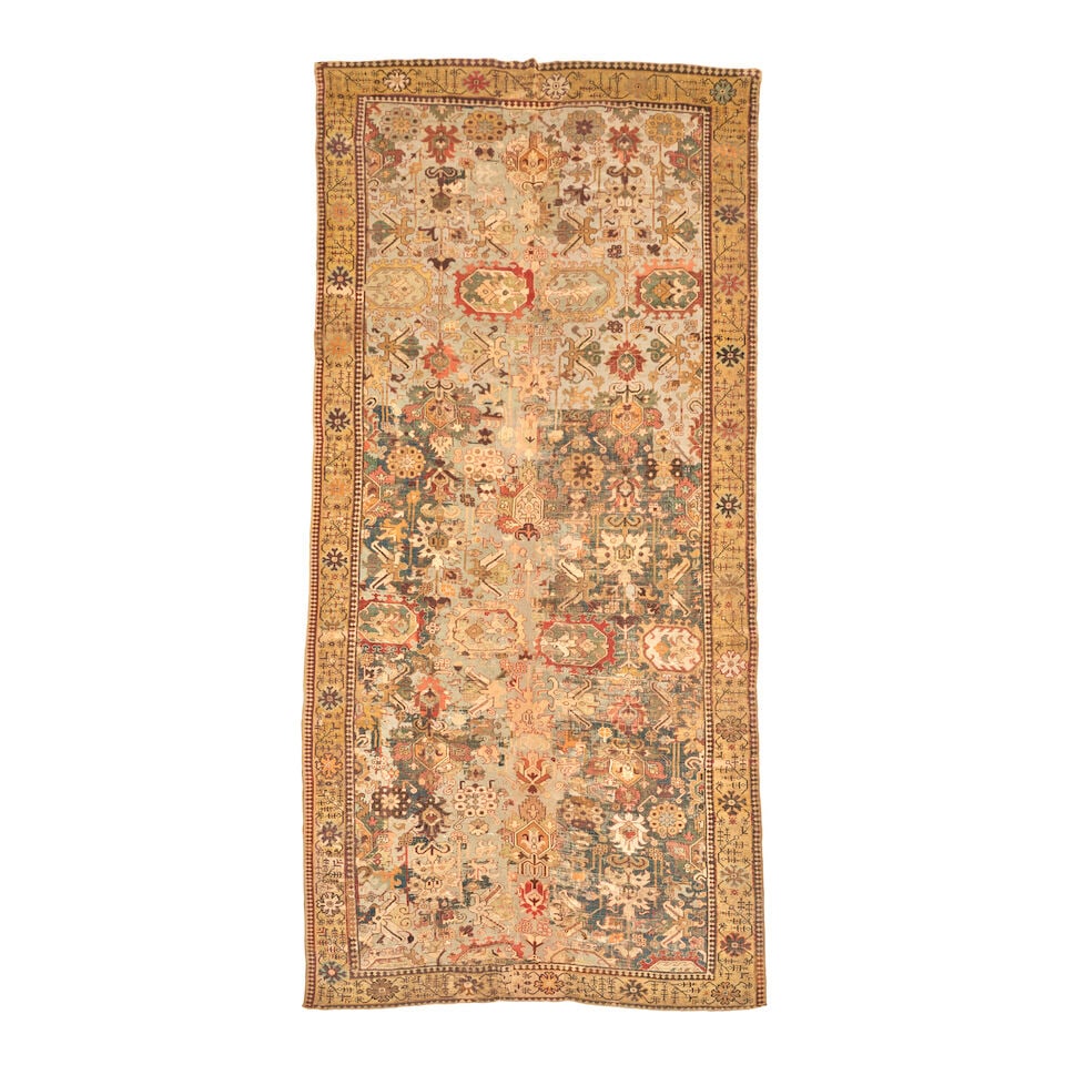 Early Kuba Gallery Carpet Caucasus 7 ft. 1 in. x 17 ft. 1 in.: Early Kuba Gallery Carpet Caucasus c. first half 18th century, a deep abrashed indigo field surrounded by a rosette and floral spray gold main border, plain and 'S' motif minor borders. A similar rug 