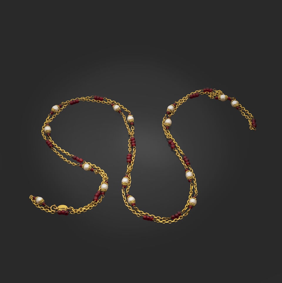 Chanel, circa 1983. Long sautoir chaine doré entrecoupée de perles rouges et perles d'...: Chanel, circa 1983. Long sautoir chaine doré entrecoupée de perles rouges et perles d'imitations chapeautées dorées et blanches. Chanel, circa 1983. Long gold-tone chain sautoir