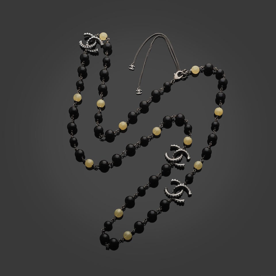 Chanel, collection Prêt à Porter, Automne/Hiver 2015. Sautoir de perles d'imitation no...: Chanel, collection Prêt à Porter, Automne/Hiver 2015. Sautoir de perles d'imitation noires et translucides. Directeur artistique: Karl Lagerfeld. Entrecoupées de sigles de la Maison en