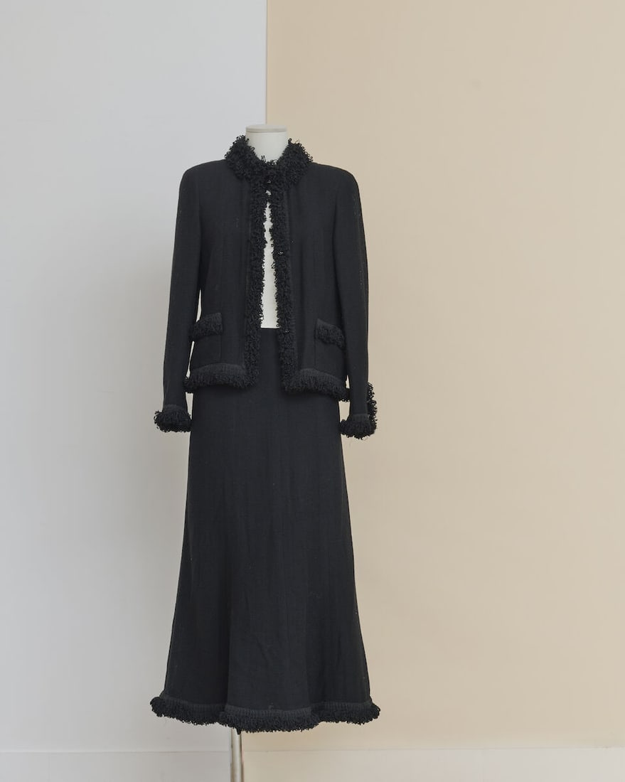 Chanel, collection Croisière 2003. Tailleur à jupe midi en laine maille noire gans...: Chanel, collection Croisière 2003. Tailleur à jupe midi en laine maille noire gansé de bouclettes. Chanel, Cruise 2003 collection. Black knit wool midi-skirt suit trimmed with