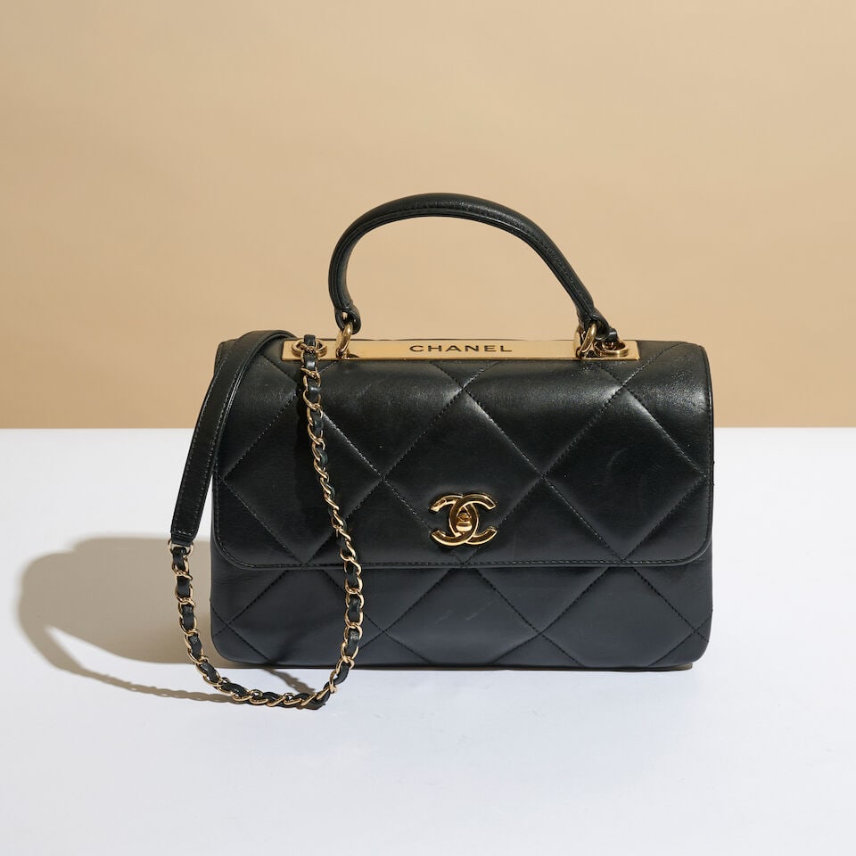 Chanel, année 2019. Sac TopHandle en cuir agneau noir à matelassage maxi et plaque dor...: Chanel, année 2019. Sac TopHandle en cuir agneau noir à matelassage maxi et plaque doré émaillée. Chanel, 2019. Top-handle bag in black lambskin with maxi-quilting and an enam