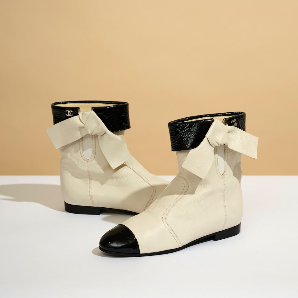 Chanel. Paire de bottines à nœud en cuir bicolore blanc et vernis noir. Chanel. Pair ...: Chanel. Paire de bottines à nœud en cuir bicolore blanc et vernis noir. Chanel. Pair of ankle boots with a bow, in white leather and black patent leather. Pointure indiquée/Size