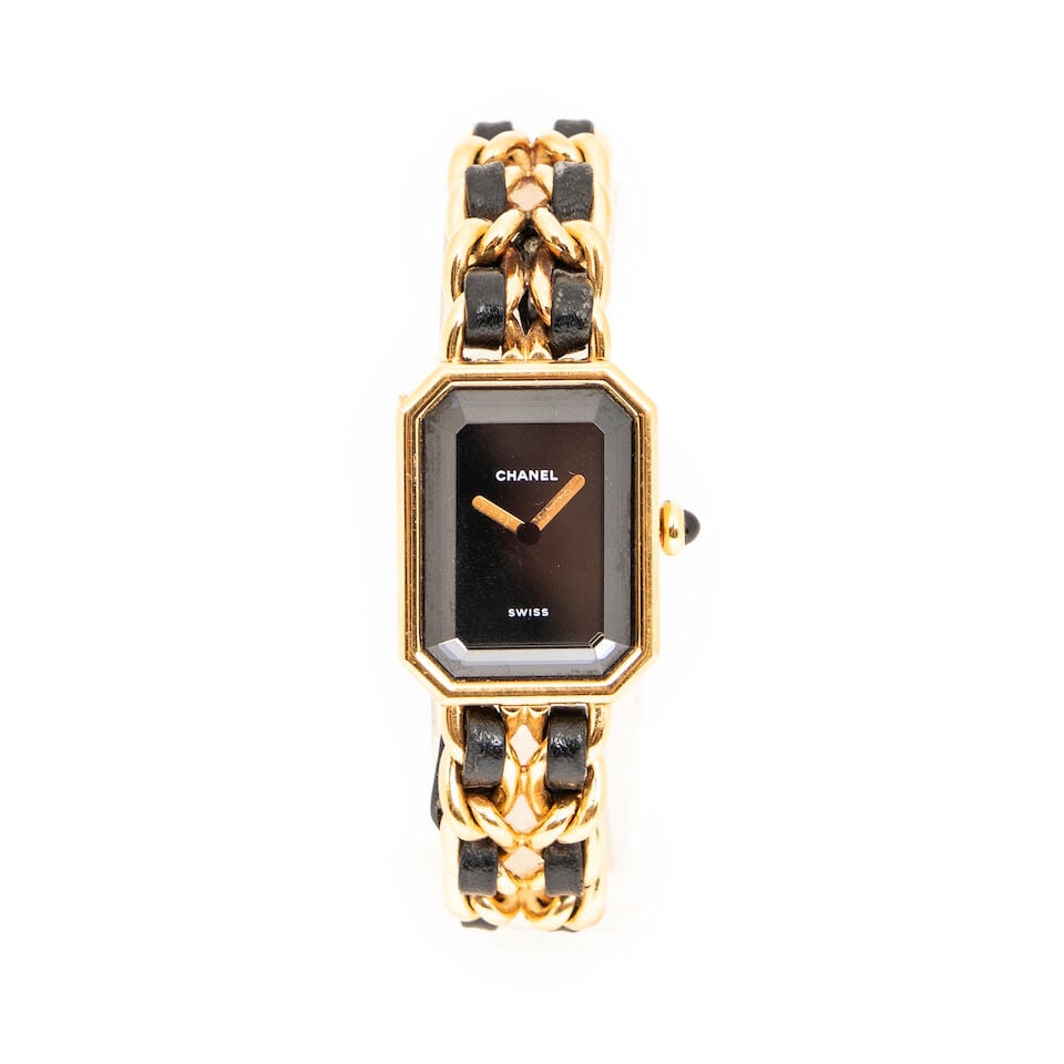 Chanel, circa 1990. Montre Première en métal doré. Chanel, circa 1990. Premiè...: Chanel, circa 1990. Montre Première en métal doré. Chanel, circa 1990. Première watch in gold-plated metal. Cadran à fond noir. Dial with a black background. Taille M - Size