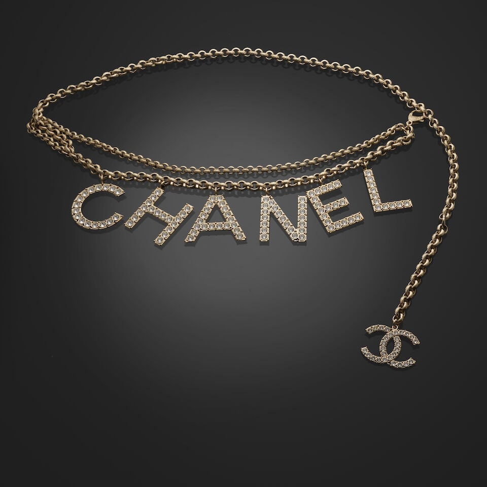 Chanel, collection Printemps/Eté 2019. Ceinture chaine à double rang au nom de la Mais...: Chanel, collection Printemps/Eté 2019. Ceinture chaine à double rang au nom de la Maison strassé. Chanel, Spring/Summer 2019 collection. Double-strand chain belt featuring the House