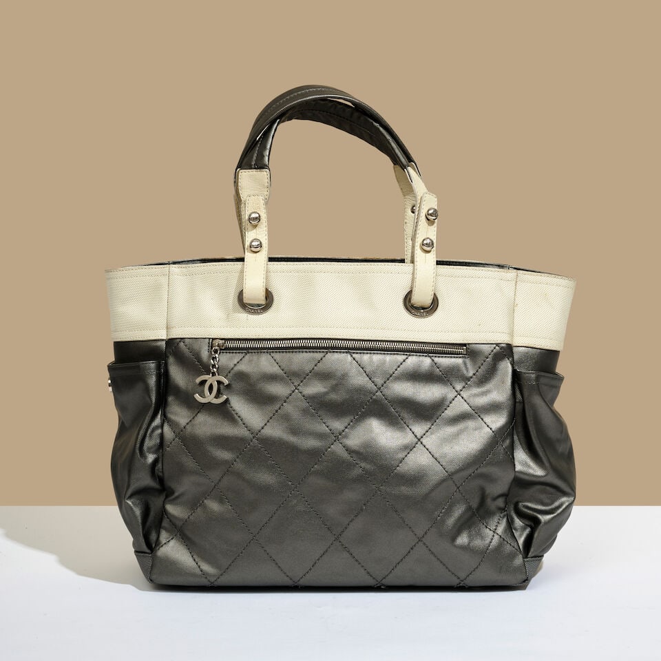 Chanel, 2006. Sac cabas zippé en toile ivoire et argent. Chanel, 2006. Ivory and silver can...: Chanel, 2006. Sac cabas zippé en toile ivoire et argent. Chanel, 2006. Ivory and silver canvas zipped tote bag. Directeur artistique: Karl Lagerfeld. Hologramme et carte