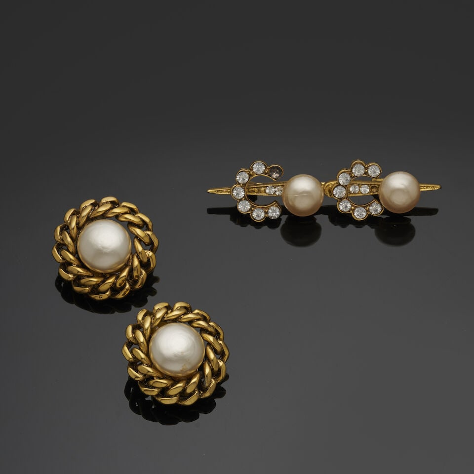 Chanel, année 1984. Paire de clips d'oreilles et broche en métal doré, strass et ...: Chanel, année 1984. Paire de clips d'oreilles et broche en métal doré, strass et perles d'imitation. Chanel, 1984. Pair of clip-on earrings and brooch in gold-tone metal, rhinestones, a