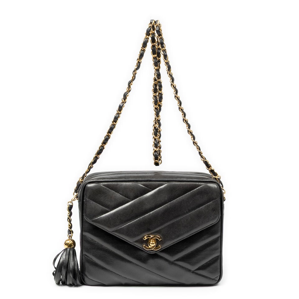 Chanel, circa 1994. Sac en cuir noir à effet de surpiqûres. Chanel, circa 1994. Black ...: Chanel, circa 1994. Sac en cuir noir à effet de surpiqûres. Chanel, circa 1994. Black leather bag with a topstitched effect. Logo en métal doré, fermeture zippée, anse cha