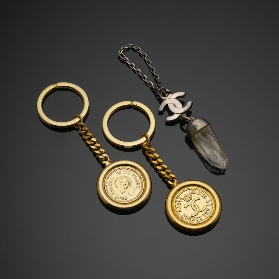 Chanel, circa 1983/1984. Trois portes clés divers. Chanel, circa 1983/1984. Three assorted ...: Chanel, circa 1983/1984. Trois portes clés divers. Chanel, circa 1983/1984. Three assorted keychains. Directeur artistique: Karl Lagerfeld. 10 cm. Footnotes: Bon état général.