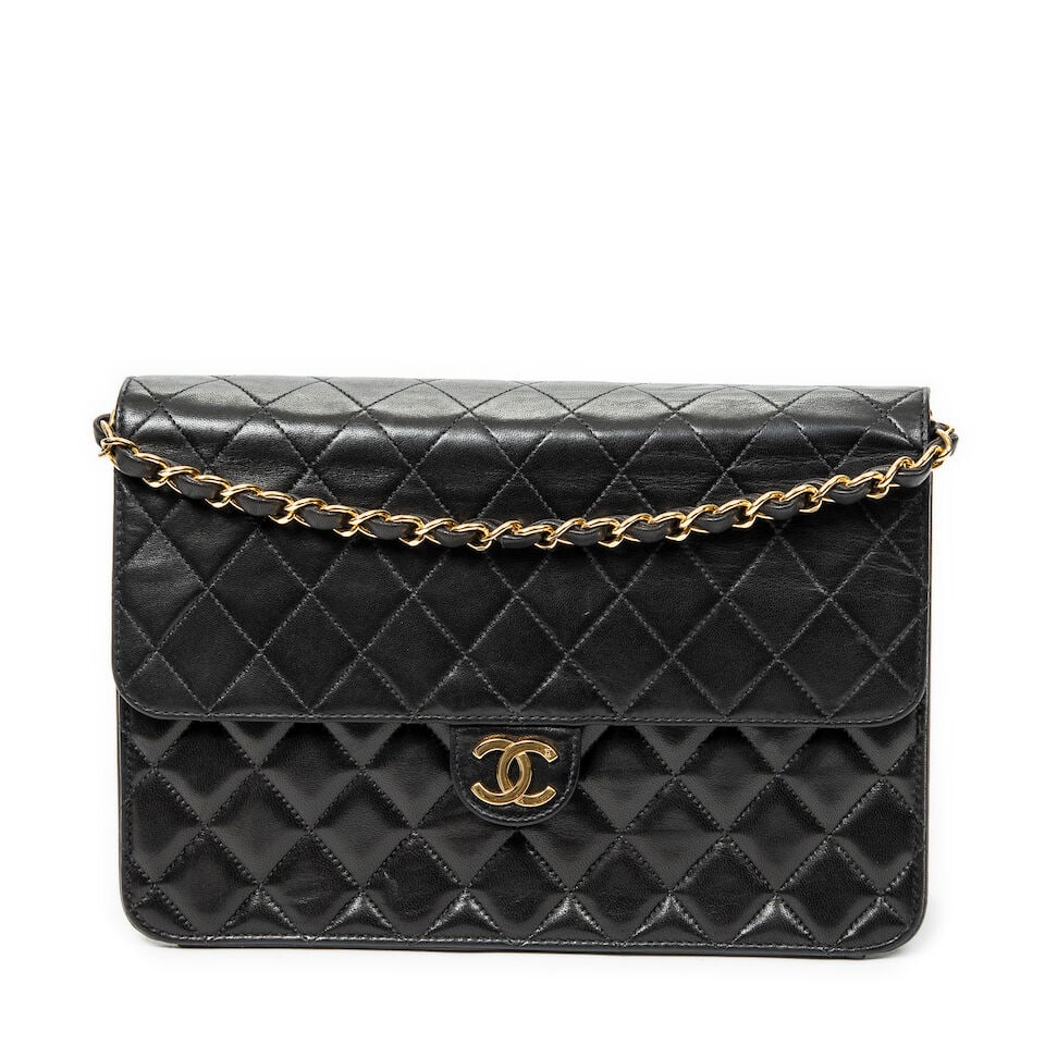 Chanel, circa 1997. Sac Classique en cuir noir matelassé. Chanel, circa 1997. Classic bag i...: Chanel, circa 1997. Sac Classique en cuir noir matelassé. Chanel, circa 1997. Classic bag in black quilted leather. Fermeture avec logo sur rabat, anse chaîne en métal doré.