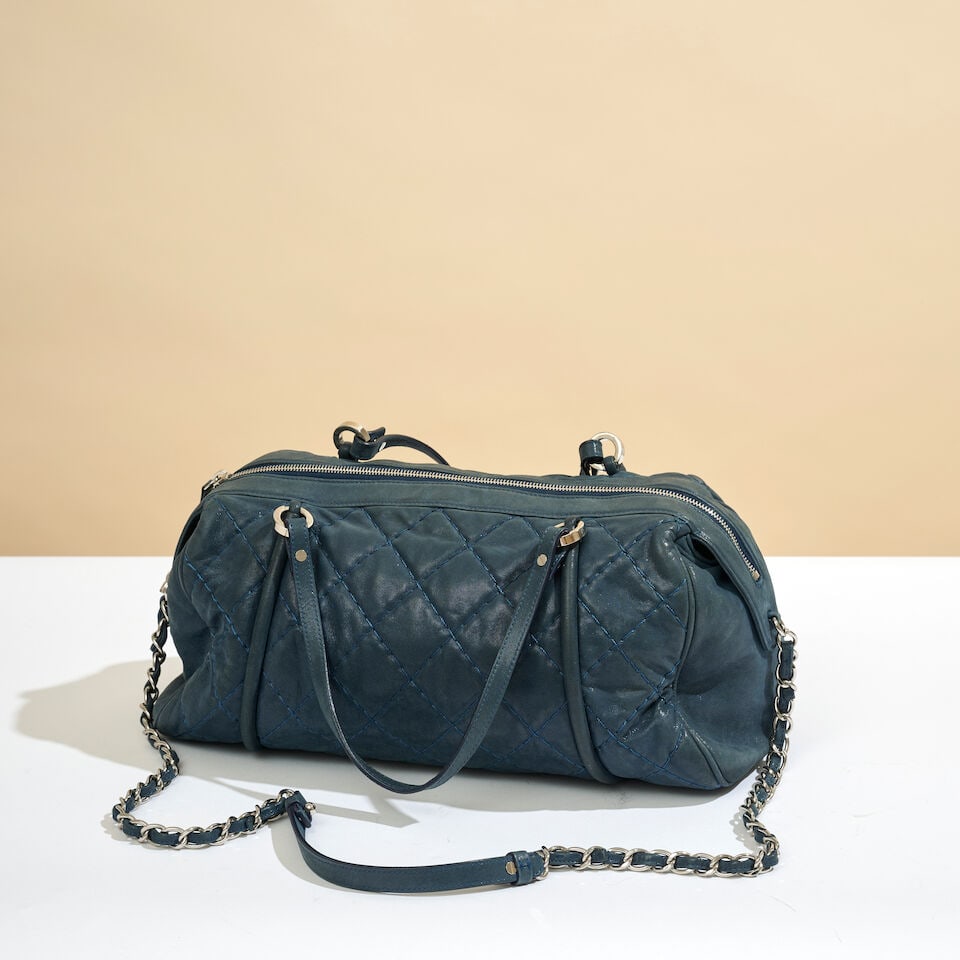 Chanel, 2012. Sac Bowling en cuir agneau irisé marine, partiellement matelassé. Chanel...: Chanel, 2012. Sac Bowling en cuir agneau irisé marine, partiellement matelassé. Chanel, 2012. Navy iridescent lambskin bowling bag, partially quilted. Directeur artistique: Karl