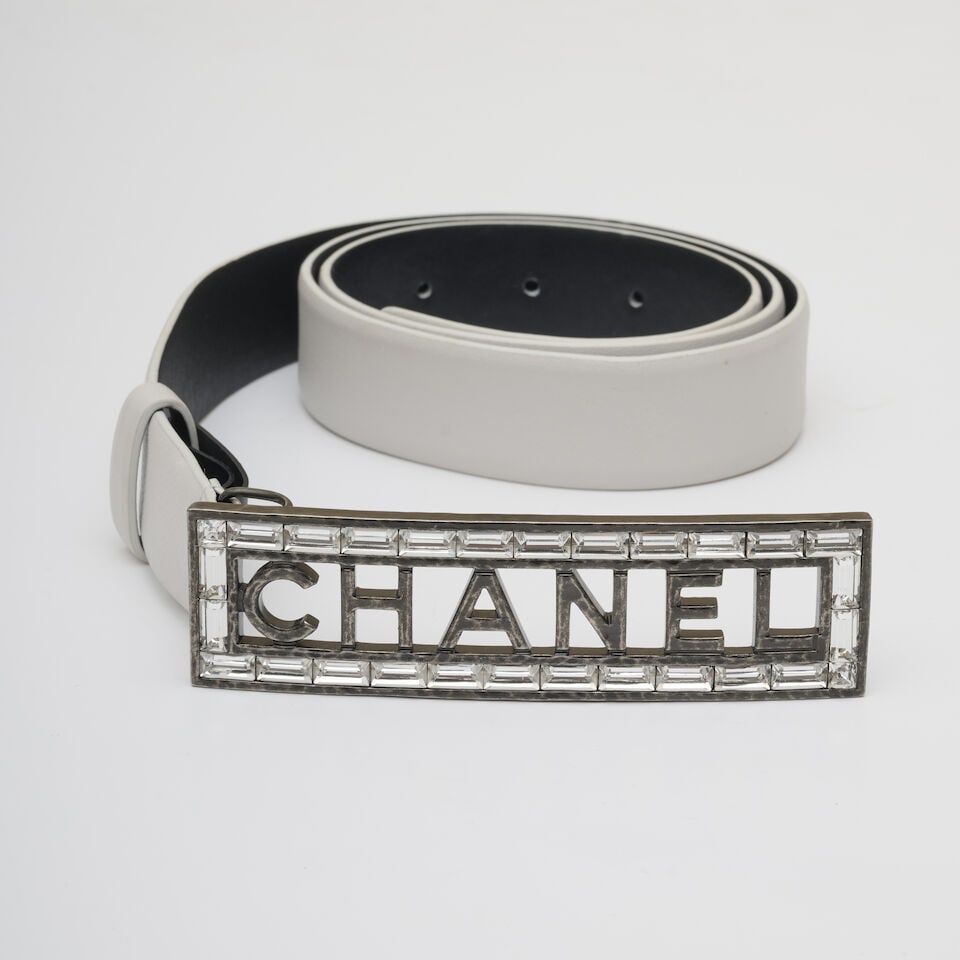 Chanel, collection Croisière 'Carrières de Lumières' 2022. Ceinture en cuir blanc...: Chanel, collection Croisière 'Carrières de Lumières' 2022. Ceinture en cuir blanc à boucle strassée au nom de la Maison. Chanel, 'Carrières de Lumières' Cruise 2022
