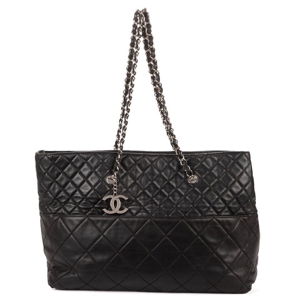 Chanel, circa 2010. Sac cabas en cuir noir matelassé. Chanel, circa 2010. Black quilted lea...: Chanel, circa 2010. Sac cabas en cuir noir matelassé. Chanel, circa 2010. Black quilted leather tote bag. Logo et double anse chaîne en métal chromé. Logo and double chain handles 