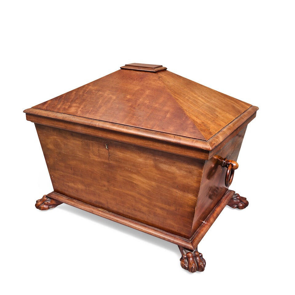 A large William IV or early Victorian mahogany cellaret 1835-1840: A large William IV or early Victorian mahogany cellaret 1835-1840 Of sarcophagus form, the hinged top surmounted by a moulded platform, enclosing a zinc lined interior with oak divisions, on an ovolo 