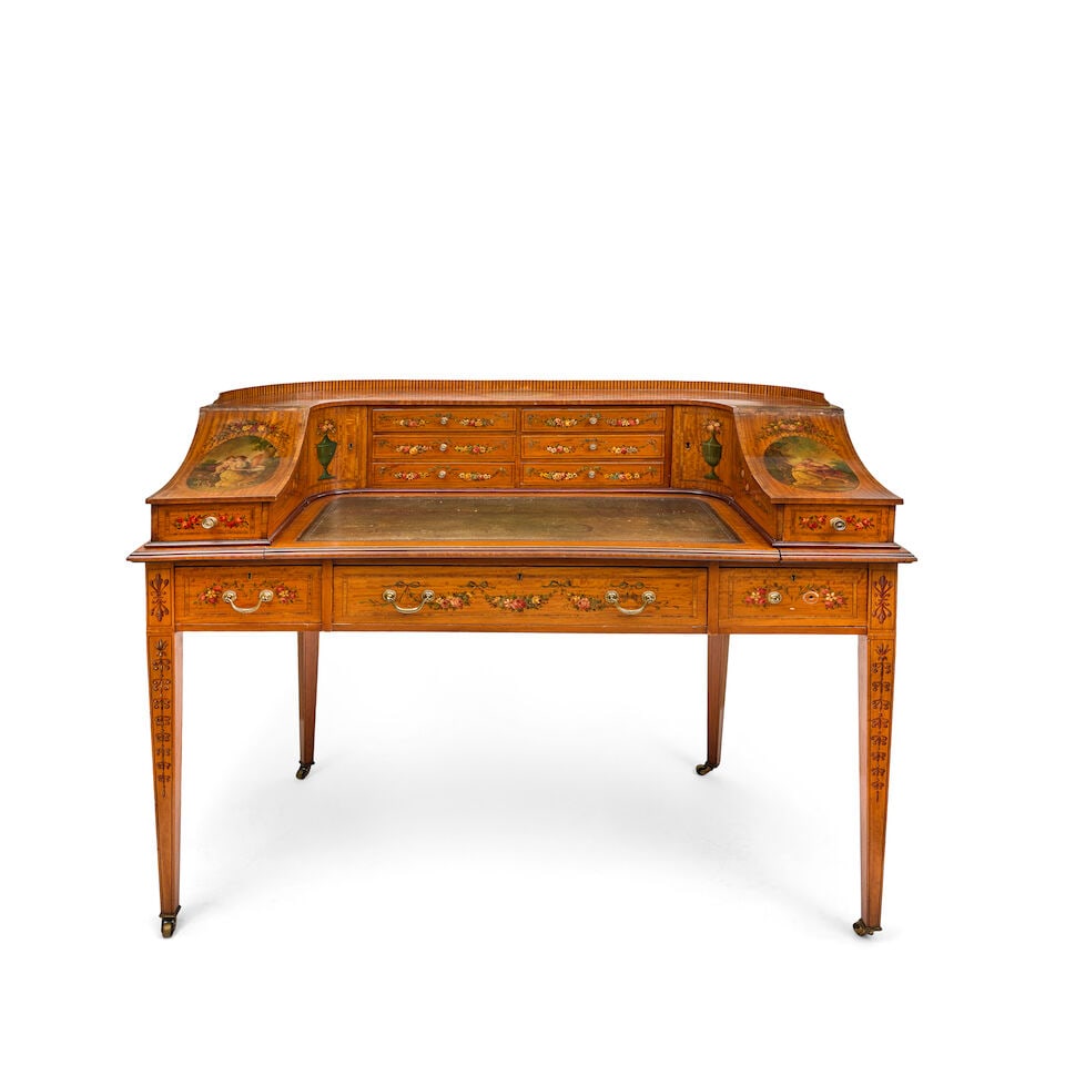 An Edwardian satinwood, rosewood crossbanded and polychrome decorated Carlton House desk by Mapl...: An Edwardian satinwood, rosewood crossbanded and polychrome decorated Carlton House desk by Maple & Co. Circa 1910 Painted with ribbon tied floral festoons, twin handled Neoclassical urns, scrolled st
