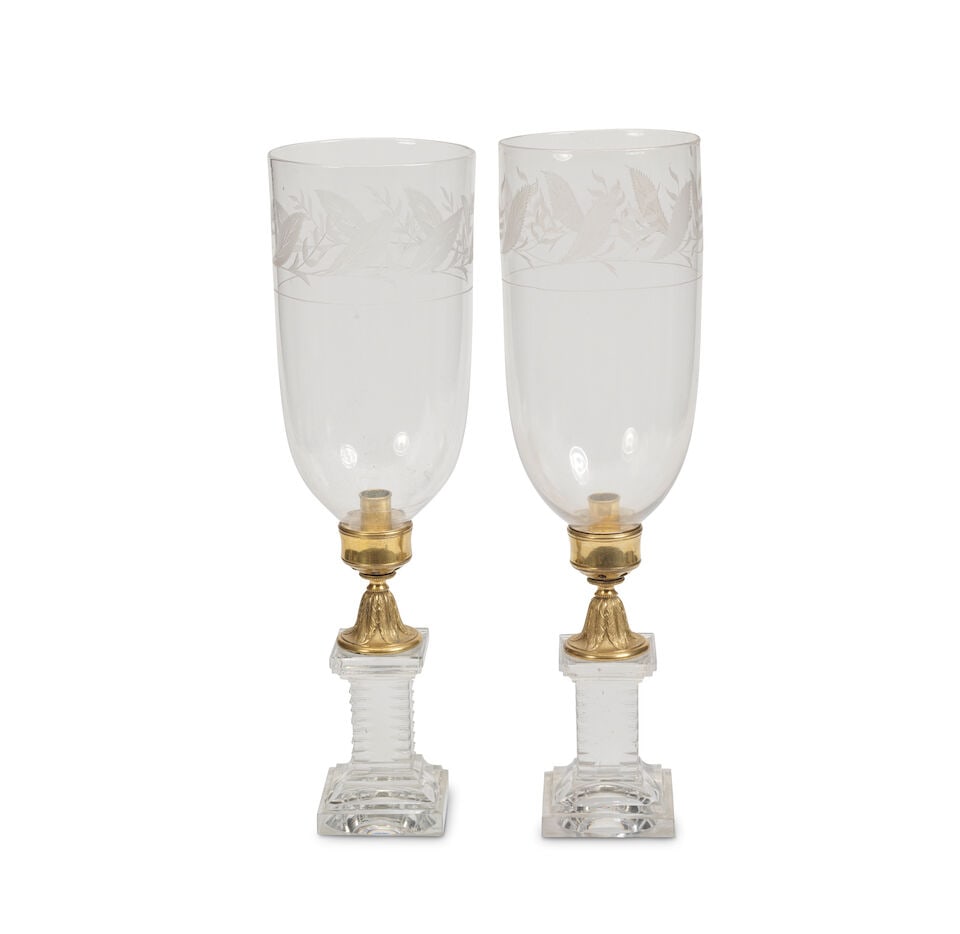 A pair of George III cut glass and gilt bronze storm lanterns In the manner of William Parker (E...: A pair of George III cut glass and gilt bronze storm lanterns In the manner of William Parker (English, d.1817), the shades probably late 19th century The bases of rectangular pedestal form with notch