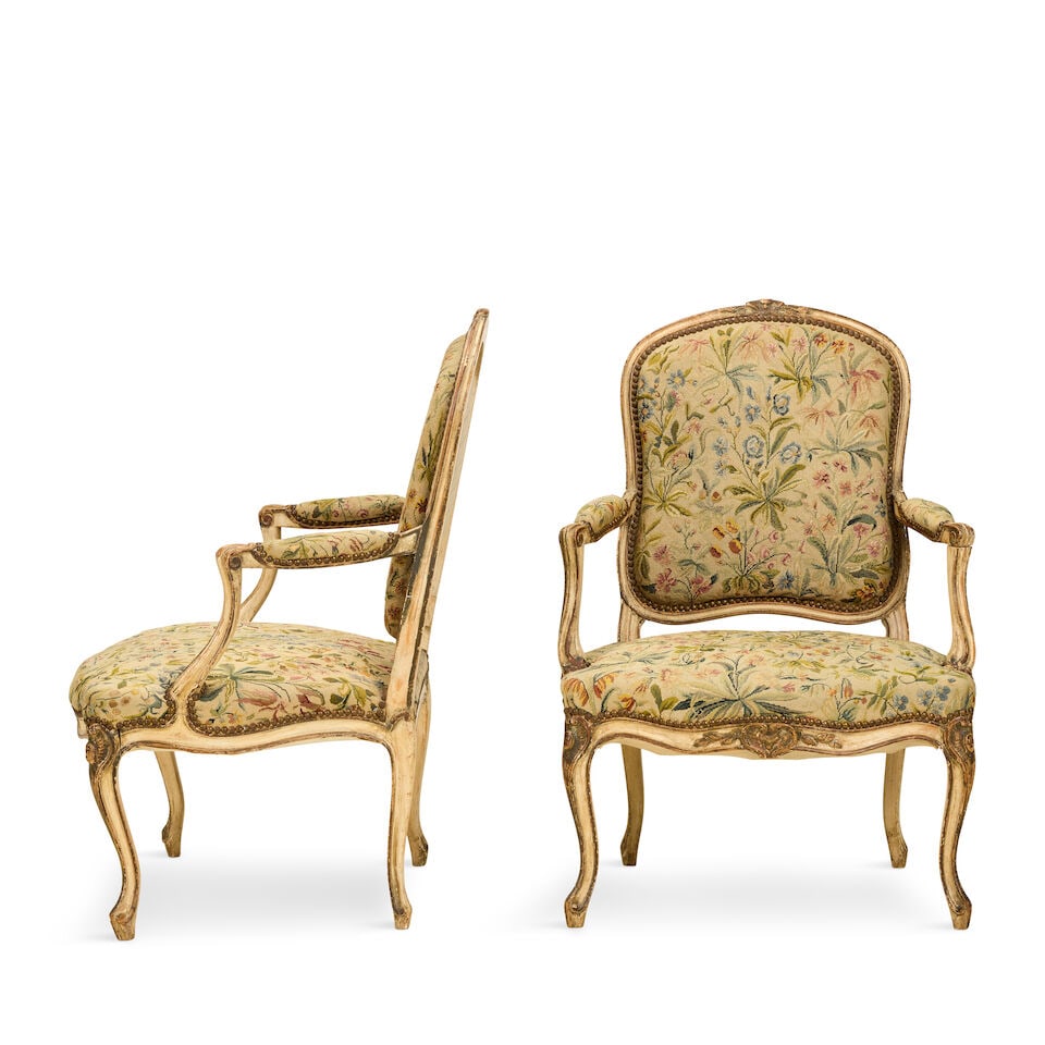 A pair of French early 20th century painted fauteuils or open armchairs 1900-1915, in the Louis ...: A pair of French early 20th century painted fauteuils or open armchairs 1900-1915, in the Louis XV style Each with cabochon embedded scrolled cartouche, foliate and rocaile carved and channelled frame
