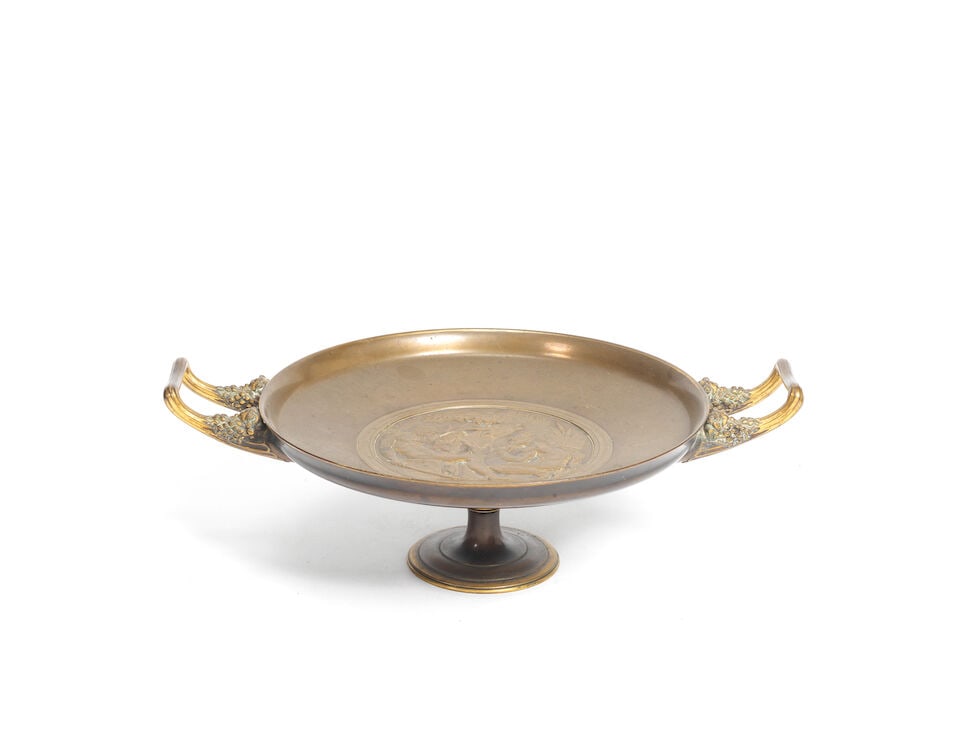 Ferdinand Levillain (French, 1837-1905): A late 19th century patinated bronze tazza cast by Fer...: Ferdinand Levillain (French, 1837-1905): A late 19th century patinated bronze tazza cast by Ferdinand Barbedienne of circular dished low pedestal form with bearded maskhead twin handles, the centre ca
