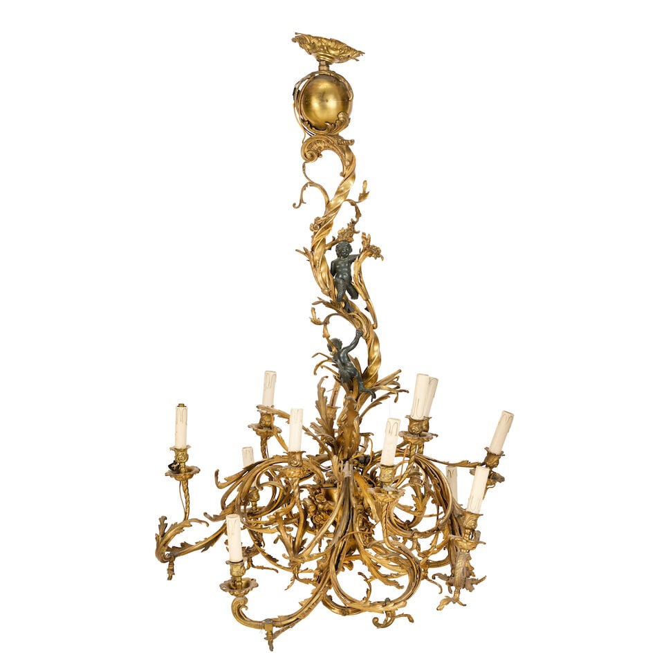 A late 19th century French gilt bronze and patinated figural twelve-light gilt and patinated bro...: A late 19th century French gilt bronze and patinated figural twelve-light gilt and patinated bronze chandelier In the Louis XV style The elaborate asymmetric acanthus scrolling arms with leafy