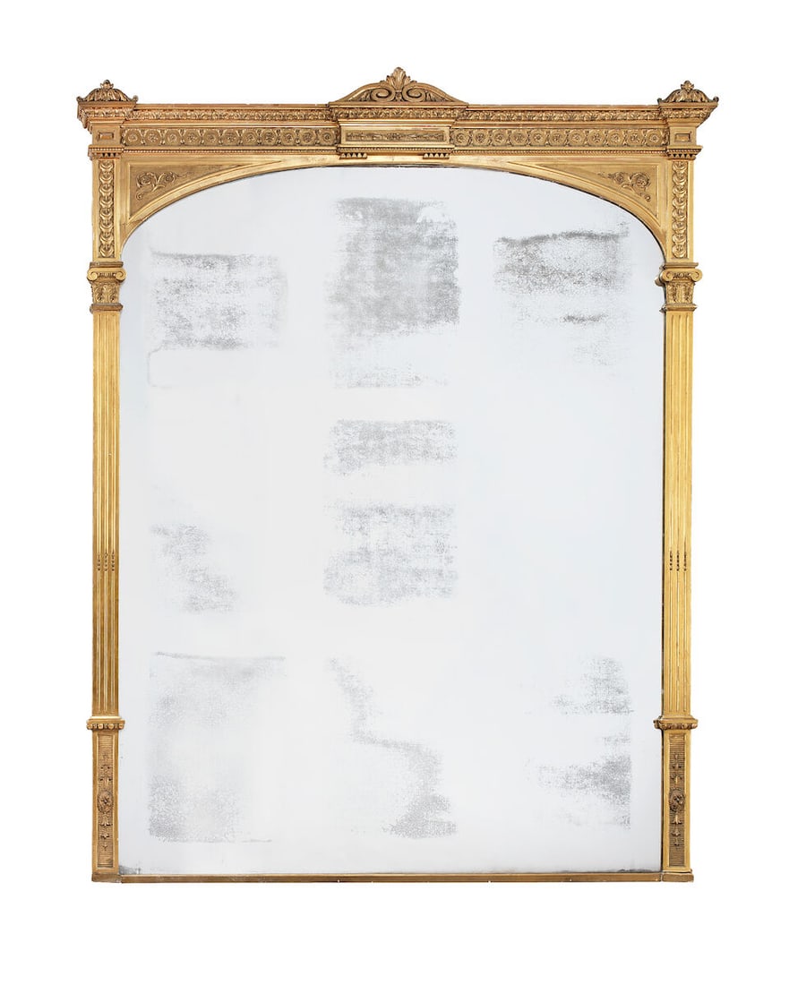 A very large mid Victorian giltwood and gilt composition overmantel mirror Circa 1865: A very large mid Victorian giltwood and gilt composition overmantel mirror Circa 1865 The arched plate flanked by stop-fluted Corinthian pilasters each with an egg and dart moulded and stiff leaf wrap