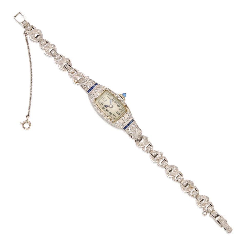 LATE ART DECO DIAMOND AND SAPPHIRE WRISTWATCH: LATE ART DECO DIAMOND AND SAPPHIRE WRISTWATCH • Platinum watch case and 14K white gold bracelet • Numerous round shaped diamonds weighing approximately 0.70 carat total • Ten square