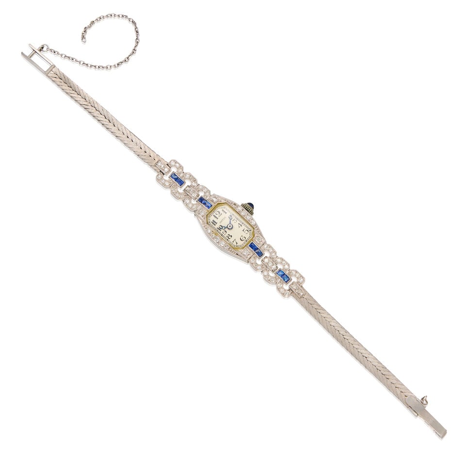 ARTIS: AN ART DECO DIAMOND AND SYNTHETIC SAPPHIRE WRISTWATCH: ARTIS: AN ART DECO DIAMOND AND SYNTHETIC SAPPHIRE WRISTWATCH • Platinum watch case and 18K white gold bracelet • Numerous round shaped diamonds weighing approximately 0.60 carats