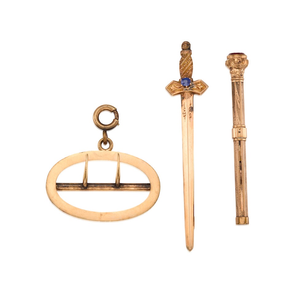 AN ANTIQUE RETRACTABLE PICK, BROOCH AND BUCKLE PENDANT: AN ANTIQUE RETRACTABLE PICK, BROOCH AND BUCKLE PENDANT • One 9K gold retractable pick with one round shape glass, measures 2 1/4 in. x 1/4 in. • One 13K gold brooch with one oval shaped sa