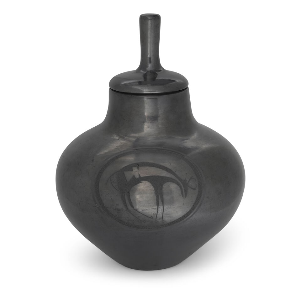 A Maria Martinez and Tony Da sgraffito blackware lidded jar: Maria Martinez and Tony Da San Ildefonso, (1887-1980 and 1940-2008), a high-luster blackware lidded jar, undecorated save for two opposing ovoid registers centering sgraffito depictions of heartline d
