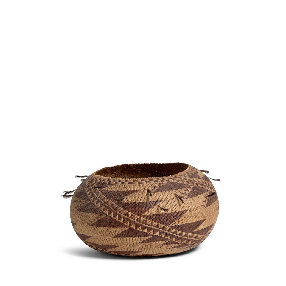 A Pomo basket: A Pomo basket A twined bamtush bowl, finely woven with complex diagonal whorls ascending from the base to the rim, quail topknot accents. diameter 10 1/2in, height 5 3/4in Footnotes: Marcy Burns