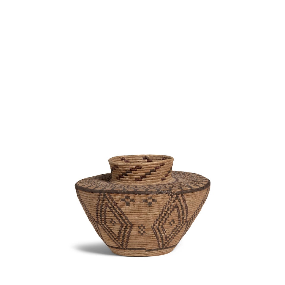 A Yokuts polychrome bottleneck basket: A Yokuts polychrome bottleneck basket A dense zigzag encircling the pronounced neck, concentric diamonds extending below the shoulder to the base. diameter 8in, height 5 3/4in Footnotes: Provenance A