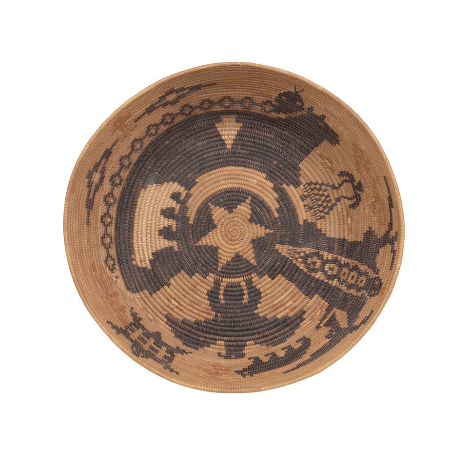 A Southern California polychrome pictorial basket: A Southern California polychrome pictorial basket Woven in an asymmetrical design in positive and negative fields, showing a profusion of bears, snakes, spread-winged eagle, butterflies, a tortoise or