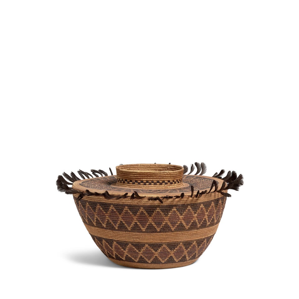 A Yokuts polychrome bottleneck basket: A Yokuts polychrome bottleneck basket Two broad rattlesnake bands about the body, another about the base of the checkerboard-ringed neck, quail topknots encircling the shoulder. diameter 9 3/4in,